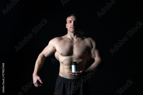Athletic bodybuilder isolated on black background.