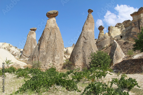 Rocks looking like mushrooms dramatically lit by a sun in Chavushin in Cappadocia, Turkey. photo