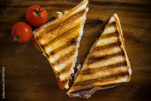 grilled panini with tomatos on wooden board 