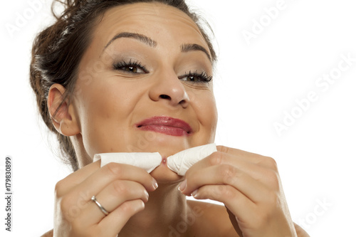 a young woman squeezes the pimple on her chin