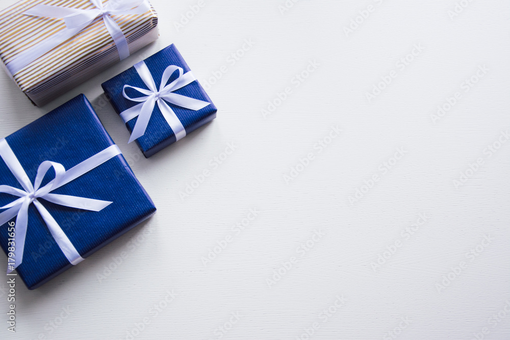 Background on a white desk decorated presents. Bright background symbolizes the new year celebration. Great useful template to wright words down. Red bow on a box. Beautiful packaging for present. Background on a white desk decorated presents. Bright background symbolizes the new year celebration. Great useful template to wright words down. Red bow on a box. Beautiful packaging for present.