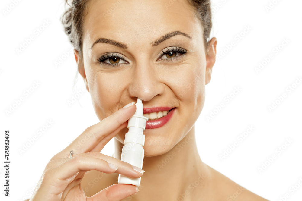 young woman spraying a nose drops in her nose