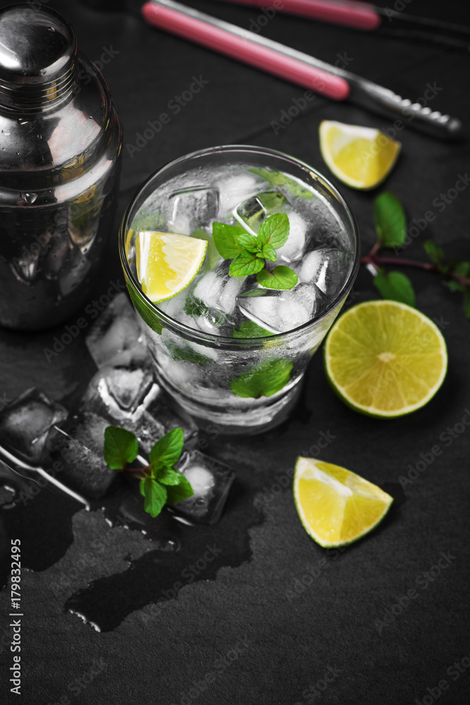 Mojito cocktail with lime and mint in glass on a grey stone background Mojito cocktail with lime and mint in glass on a grey stone background