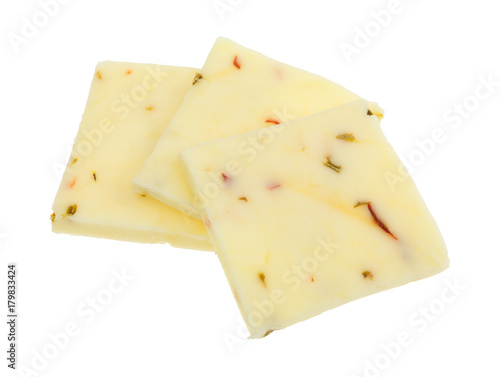 Three squares of fresh pepper jack cheese isolated on a white background.