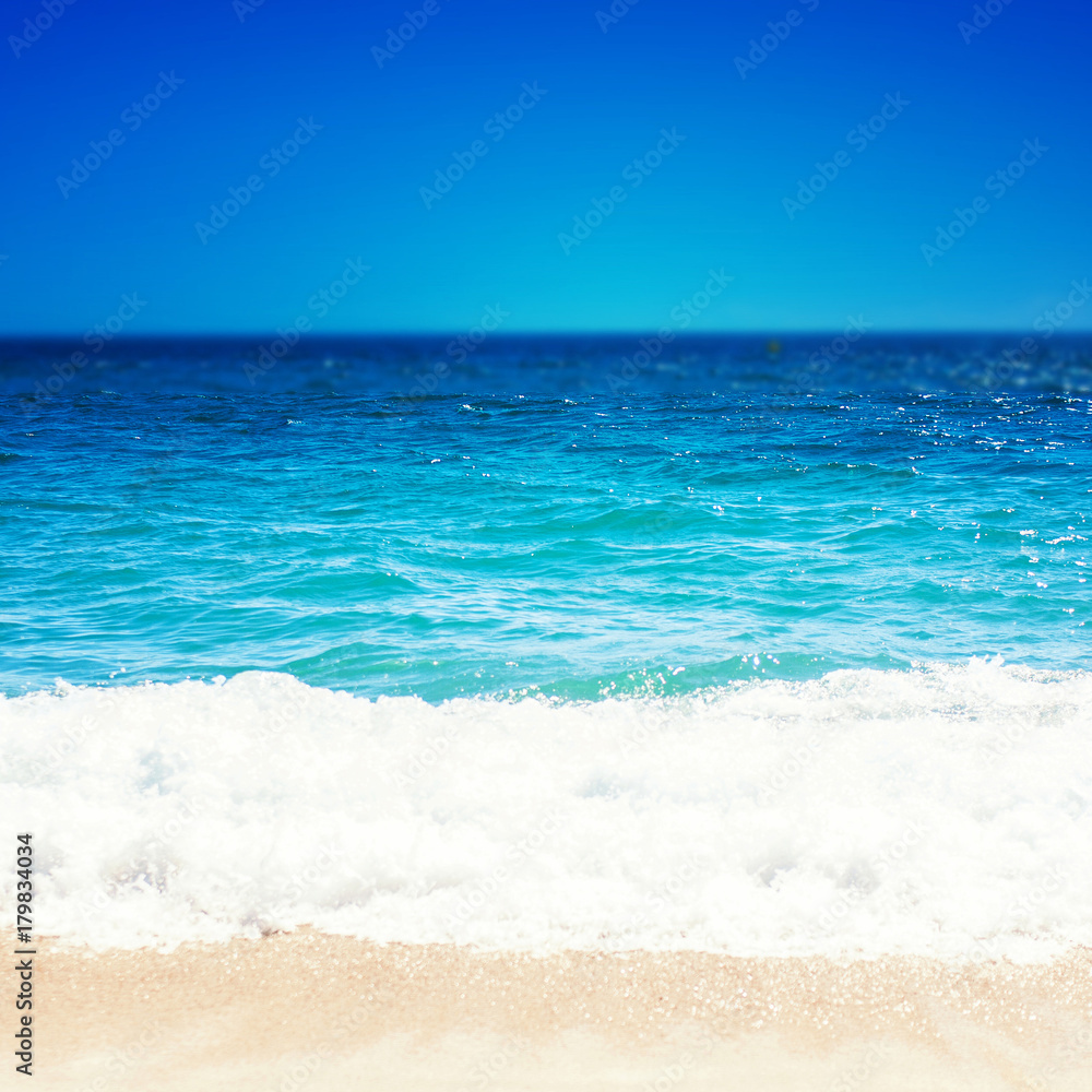 Fototapeta premium Sea Beach i miękka fala błękitnego oceanu. Letni dzień i tło piaszczystej plaży.