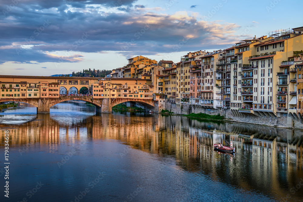 Florence cityscape view with Ponte Vecchio, a medieval stone bridge over Arno River.