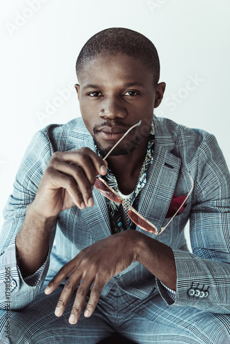 Stylish man holding sunglasses