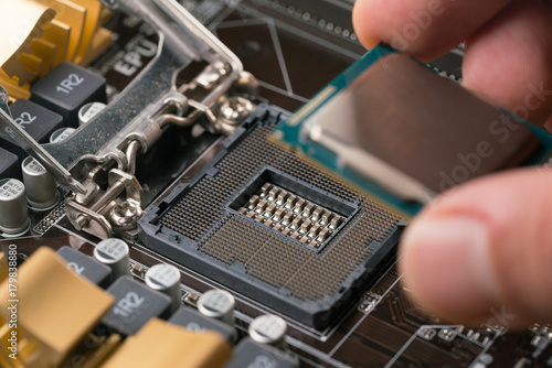 Technician plug in CPU microprocessor to motherboard socket