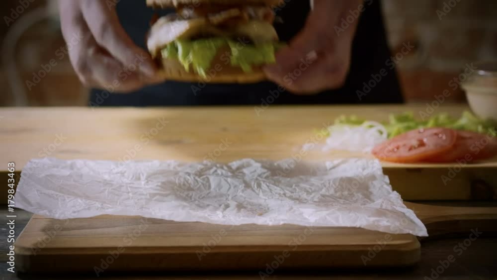 Cooking burger. Close-up shot of chef's hands putting a delicious prepared hamburger with beef rissole on a foreground. 4K Cooking burger. Close-up shot of chef's hands putting a delicious prepared hamburger with beef rissole on a foreground. 4K
