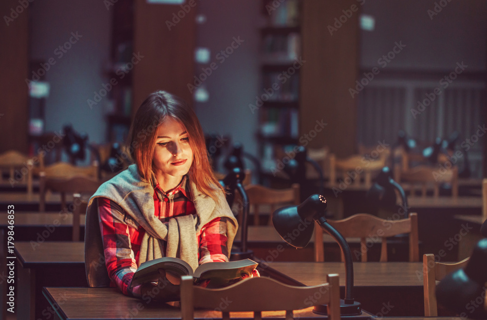 Successful casual stylish student girl wears glasses read book in reading hall in the library, education concept Successful casual stylish student girl wears glasses read book in reading hall in the library, education concept