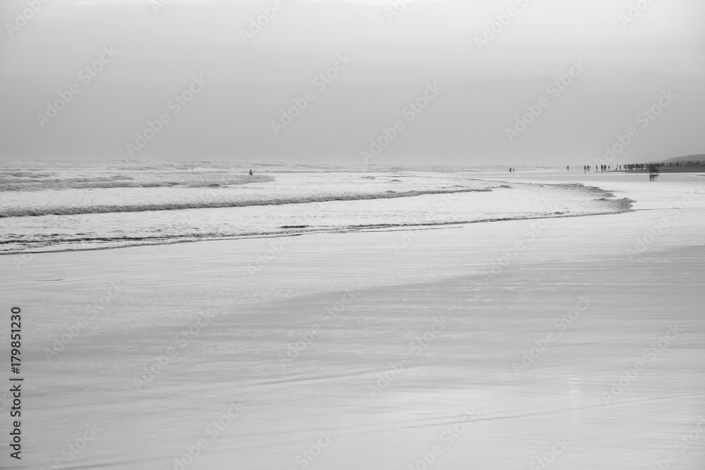 ocean shore at Parangtritis, people silhouettes, Java island, Indonesia - black and white, soft tones