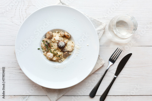 Grate parmesan on wild mushrooms porcini risotto, italian cuisine top view © Prostock-studio