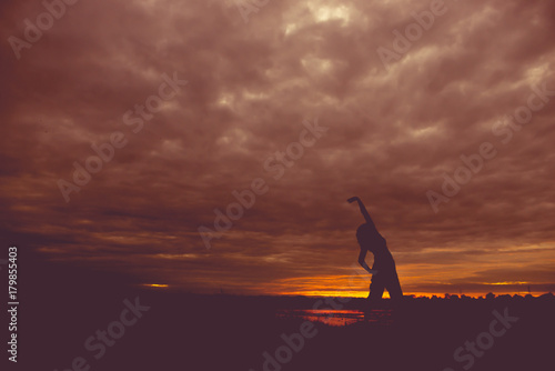 Silhouette of asian woman play yoga on sunset
