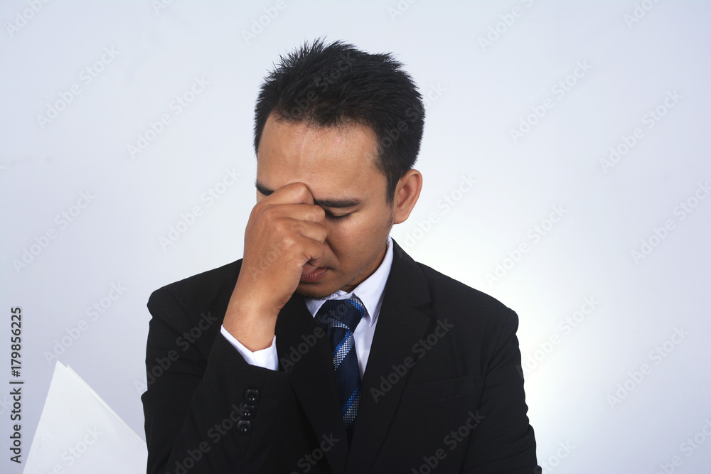 Asian young businessman headache pinching his nose Asian young businessman headache pinching his nose