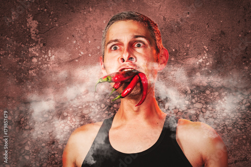 ridiculous expression of a man with hot chillies in his mouth photo