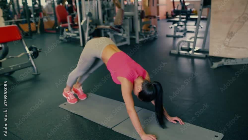 Young beautiful spotry girl with long hair doing stretching yoga exercises in the gym. 4 k Young beautiful spotry girl with long hair doing stretching yoga exercises in the gym. 4 k
