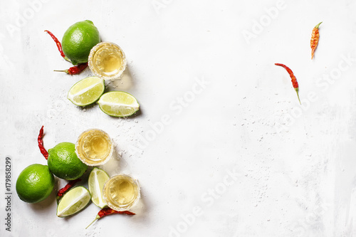 Golden tequila with lime on white drink background, top view