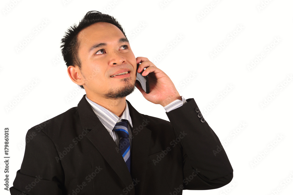 Asian businessman holding up phone to ear while look upward Asian businessman holding up phone to ear while look upward