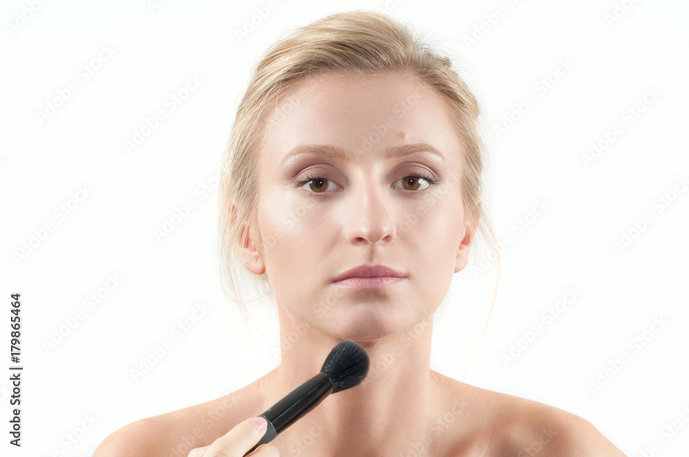 Beautiful woman applying dry cosmetic on the face using makeup brush. Beautiful woman applying dry cosmetic on the face using makeup brush.