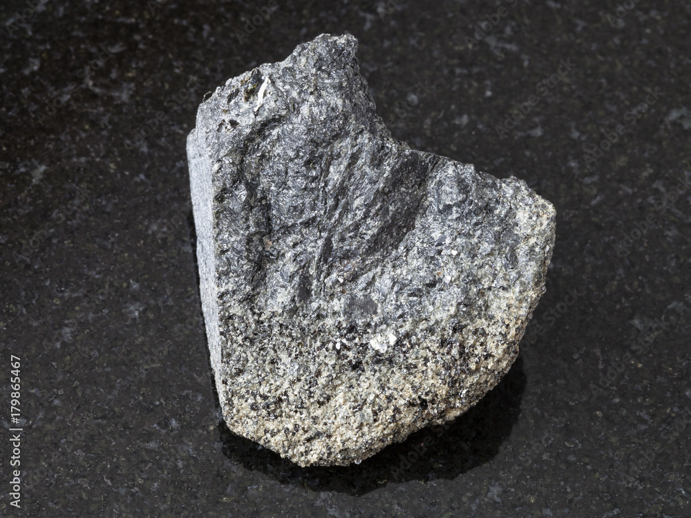 raw peridotite stone on dark background raw peridotite stone on dark background