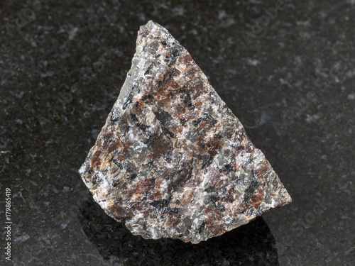 raw spreusteined urtite stone on dark photo