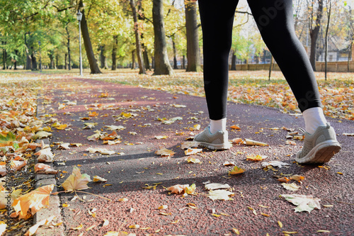 Recreation in the park during fall season - jogging and walking