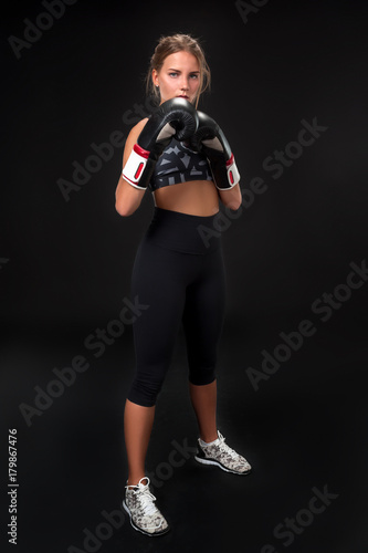 Wallpaper Mural Beautiful female athlete in boxing gloves, in the studio on a black background. Torontodigital.ca