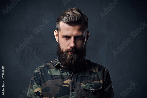 Portrait of bearded tattooed hipster male dressed in a military  © Fxquadro