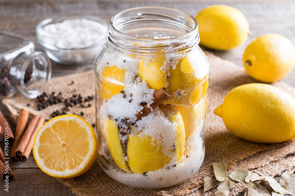 Preserved lemons with salt on a wooden board with lemon juice and spices Preserved lemons with salt on a wooden board with lemon juice and spices