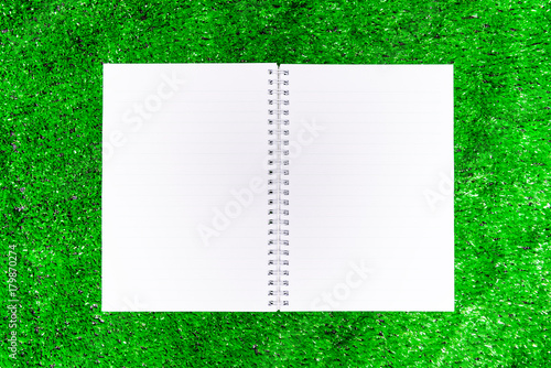 Note book placed or put on green grass.