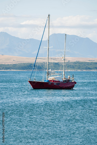 A red sailing boat on the menai strait, Anglesey