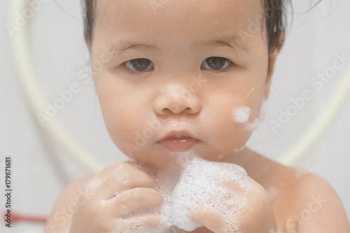 Wallpaper Mural Little asian girl taking shower in bathroom, playing bath foam bubbles. Selective focus Torontodigital.ca