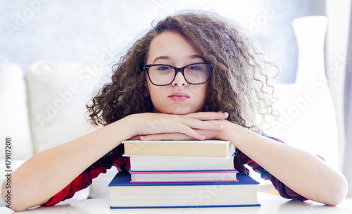 Teen girl resting on books