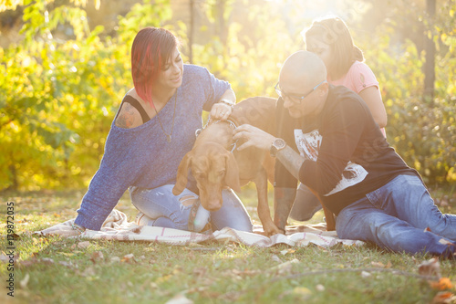 Family playing with their dog in the park. Happiness and smiles