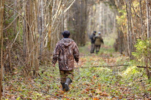 Hunter in camouflage clothes with hunting rifle during a winter hunting