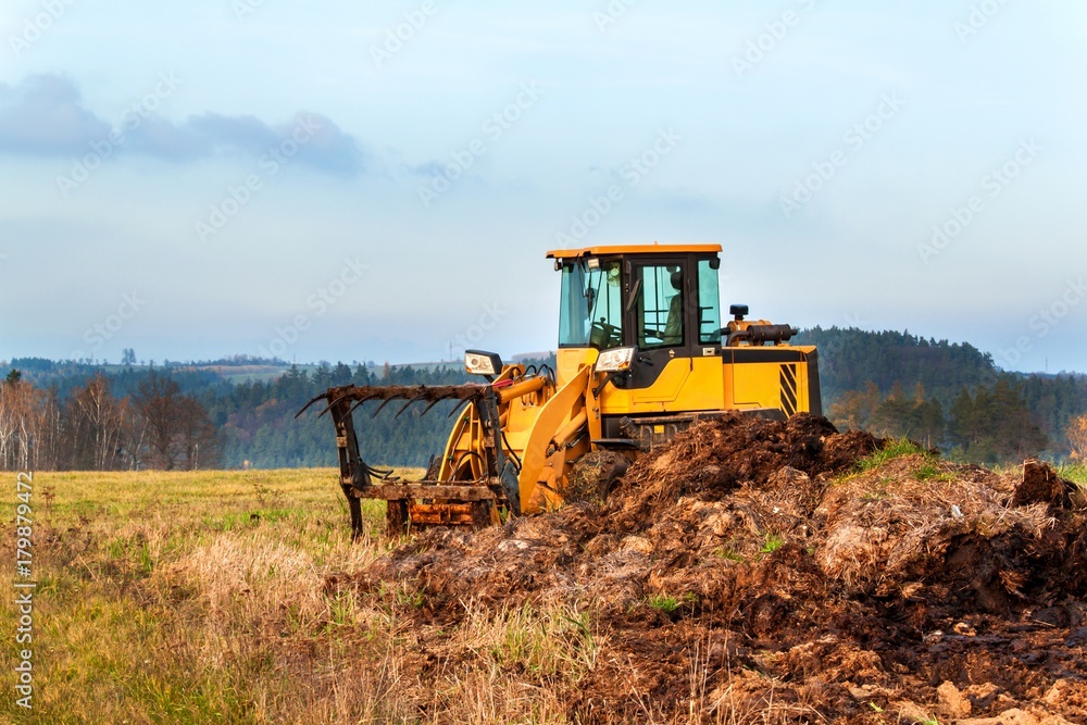 Fototapeta premium Dredger with natural manure loading trailer for field fertilization. Agricultural machine for fertilizing. Cow Dung.