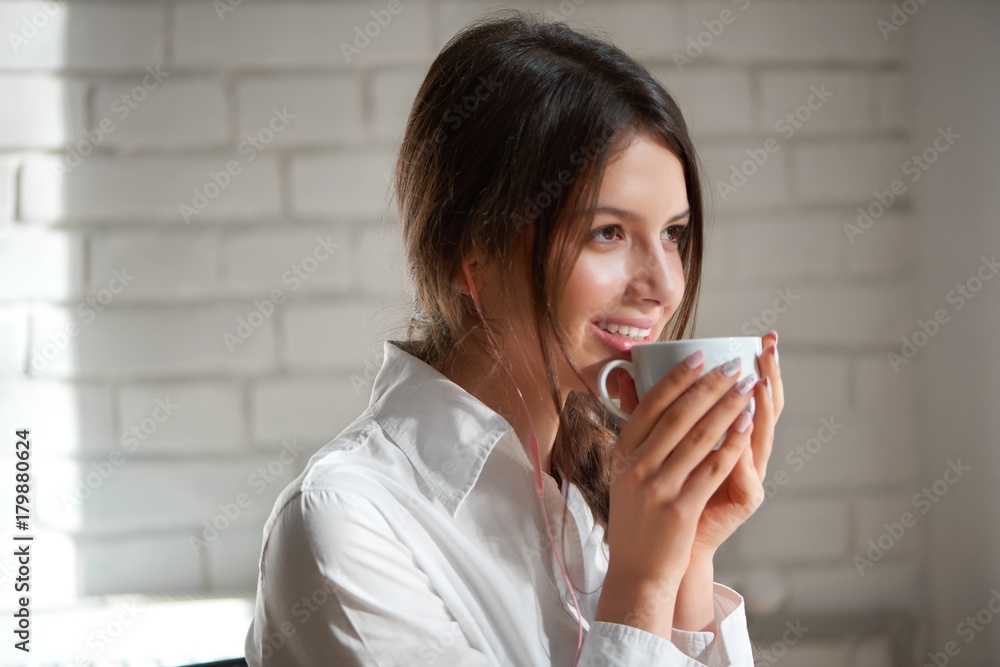 Close up portrait of a beautiful young dark haired woman smiling happily enjoying her morning cup of coffee looking away positivity beauty lifestyle relax leisure urban living youth recreation. Close up portrait of a beautiful young dark haired woman smiling happily enjoying her morning cup of coffee looking away positivity beauty lifestyle relax leisure urban living youth recreation.