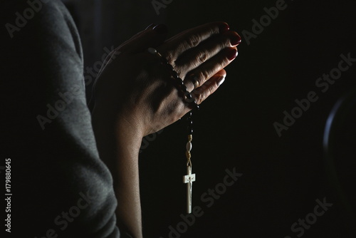 Konstfotografi Woman hands holding rosary on black background