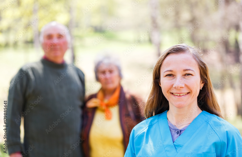 Elderly couple and young caregiver