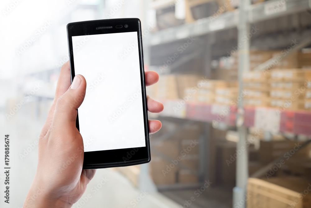 Hand using smartphone with blank screen,Blurred warehouse background Hand using smartphone with blank screen,Blurred warehouse background