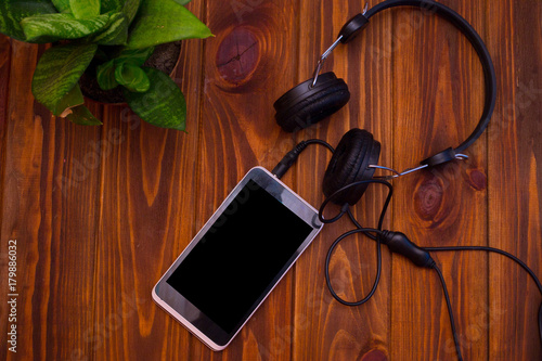Smart phone and headphones on a wooden table