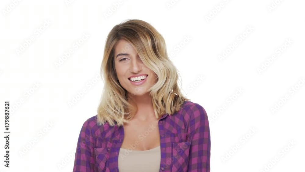 portrait of beautiful woman with hazel eyes and bright white teeth being shy smiling looking down over white background in studio. Concept of emotions portrait of beautiful woman with hazel eyes and bright white teeth being shy smiling looking down over white background in studio. Concept of emotions