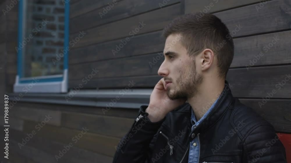 Stylish man speaking at smartphone at wooden building 4K Stylish man speaking at smartphone at wooden building 4K