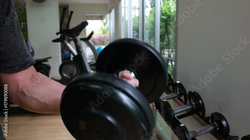 Closeup of a muscular young man lifting weights