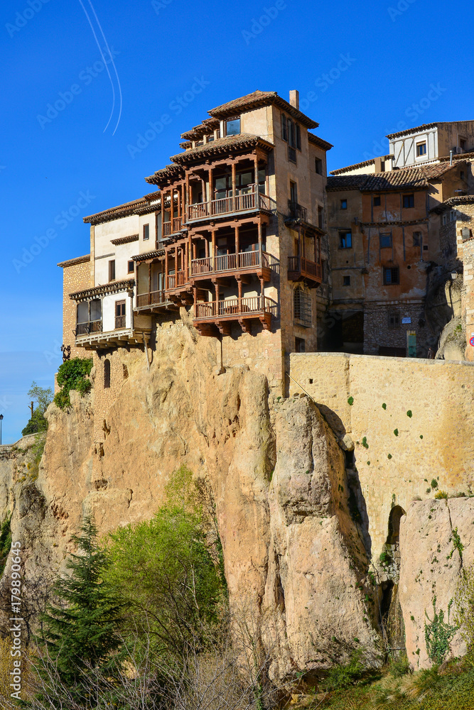 Museum of Abstract Art is in the ancient restored house hanging down over a precipice in the city of Cuenka in Spain. Two planes fly by leaving white traces in the blue sky