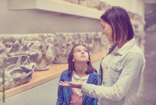 Mother and daughter exploring bas-reliefs in museum