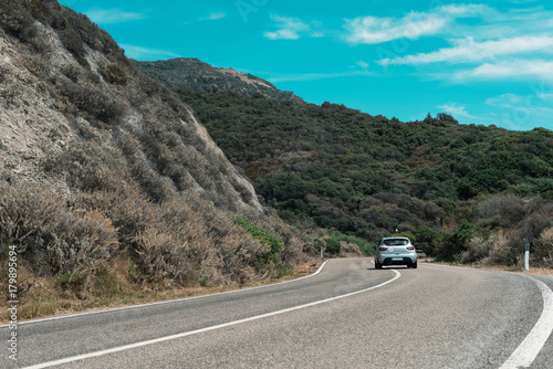 Car driving on winding mountain road. Sardinia. Italy.