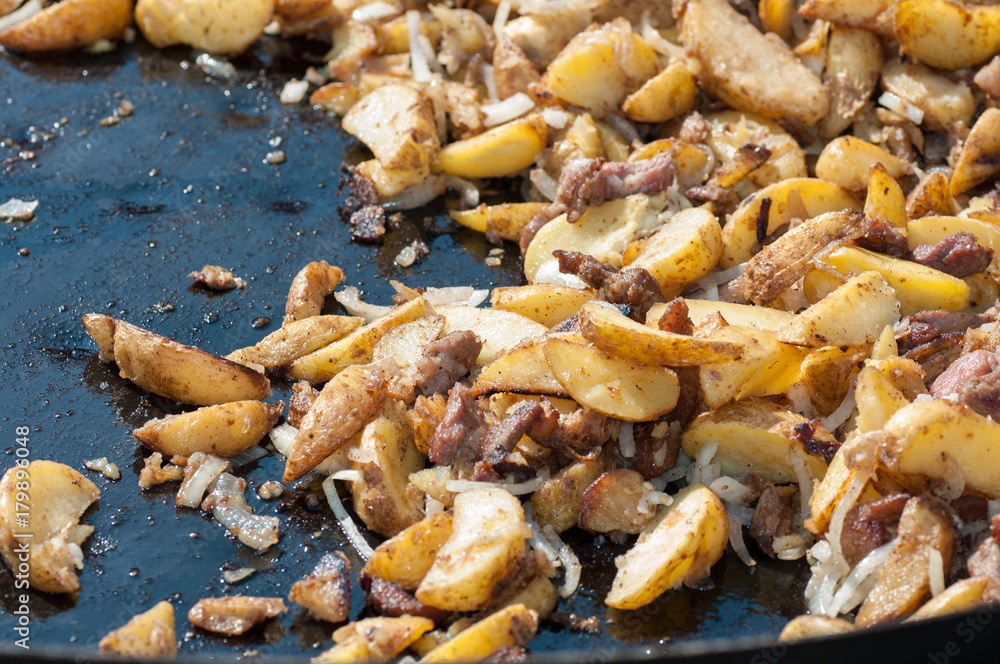 Potatoes with meat on a huge frying pan. Outdoor food. Cafe on the street. Zharkoe. Potatoes with meat on a huge frying pan. Outdoor food. Cafe on the street. Zharkoe.