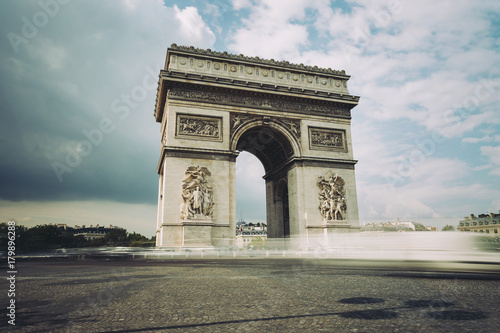 Famous Triumphal Arch, symbol of the glory and historical heritage. Iconic architectural landmark of Paris, France. Charles de Gaulle square. City traffic, tourism and travel concept. Long exposure. © sergiymolchenko