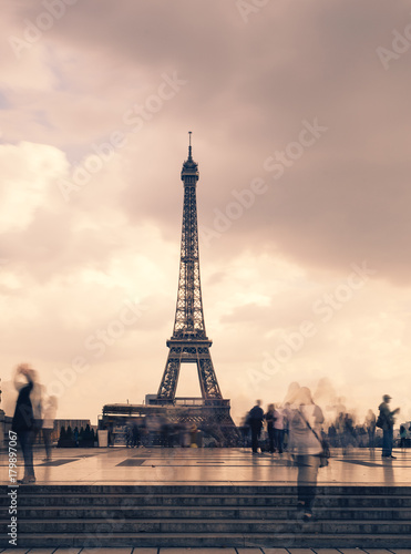 Eiffel tower, Paris symbol and iconic landmark in France, on a cloudy day. Famous touristic places and romantic travel destinations in Europe. Cityscape and tourism concept. Long exposure. Toned